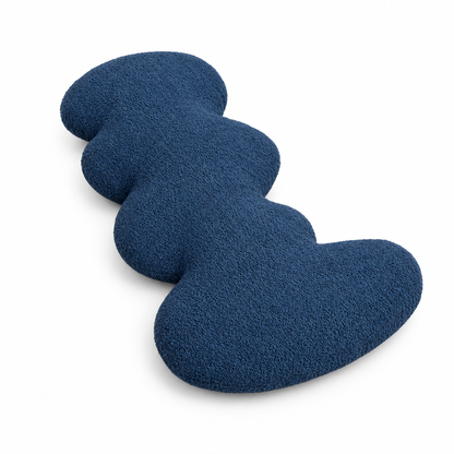 Dark blue wave accent pillow with curved silhouette on white