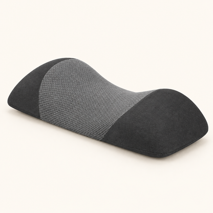 Black and gray contoured memory foam waist pillow on a warm white background