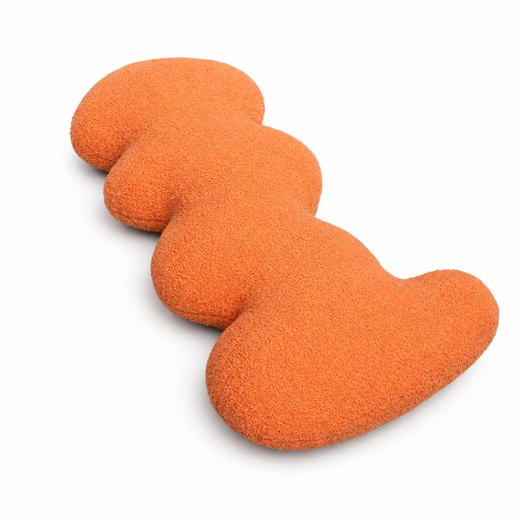 Orange wave accent pillow with curved silhouette on white